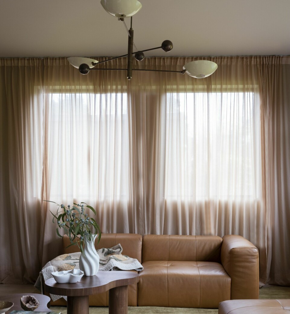 MYKE VERDIER: Gulvteppet fra Rugvista samler sofagruppen, med sofa fra Layered, en vintagestol trukket om i saueskinn av møbeltapetserer og sofabord fra Ruth & Joanna. Taklampen er kjøpt på Finn, og gardinene er fra H&M Home.