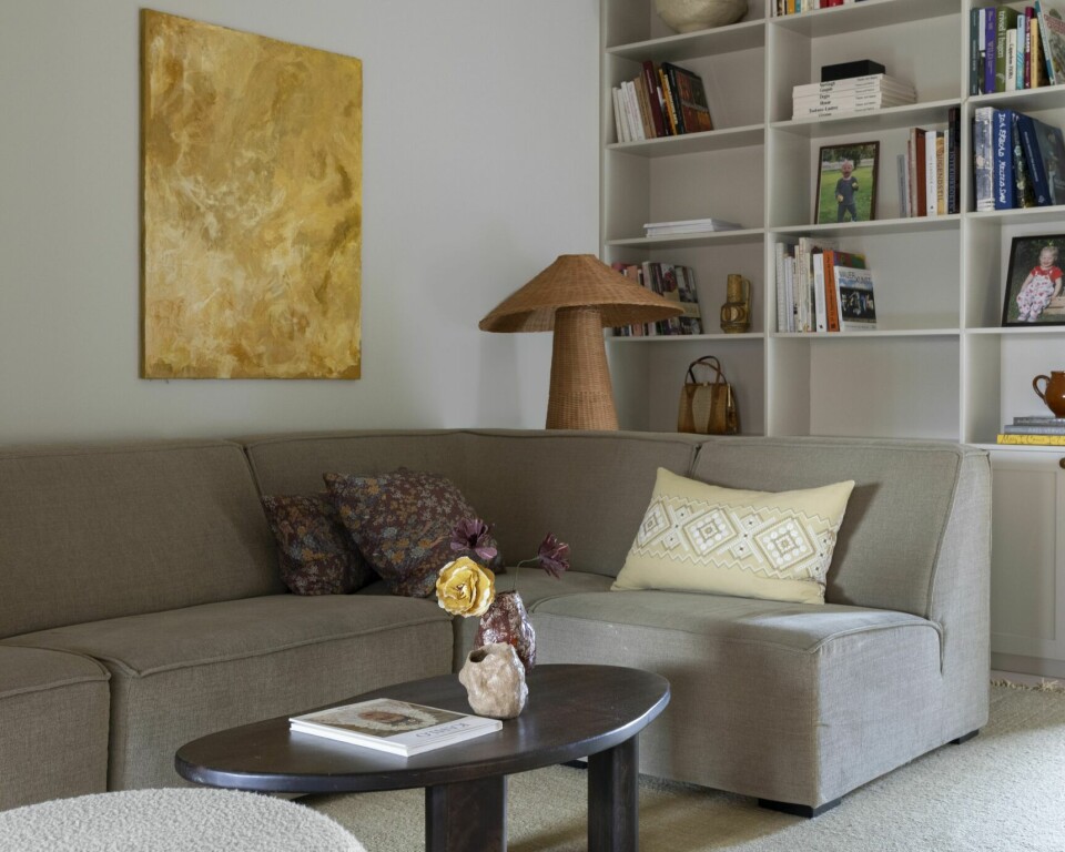 I TV-STUEN: Her er den flotte bokhyllen laget av Fjørens Møbelsnekkeri. Veggene har fargen Space fra Jotun. Sofaen er fra Bohus, sofabordet fra H&M Home og bildet på veggen er malt av Line selv. Gulvlampen er fra Ferm Living. Putene har hun sydd av vintage tekstiler.