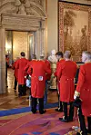 Mænd i røde uniformer står i en døråbning.