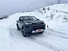 Toyota pickup kjører på snødekt vei i kupert vinterterreng