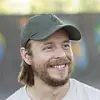 Smilende mann med grønn caps og skjegg utendørs