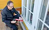 Rune Ludvigsen påfører kitt med patron langs nederste kittfals på et hvitt vindu