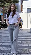 Veronica Jensen  i hvit T-skjorte og grå jeans går på brolagt bygate.