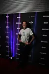 Person på rød løber foran sort væg med flere tv-logoer i baggrunden.