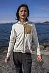 Person i Helly Hansen-jakke går på svaberg ved sjøen