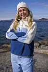 Person i Helly Hansen-fleecejakke står på svaberg ved sjøen