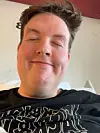 Nærbilde av en mann som tar en selfie innendørs med øynene lukket.