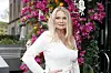 Mia Gundersen poserer foran en vegg med rosa blomster og appelsiner på Michaels i Oslo.