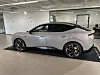 Lys sølvfarget elektrisk SUV utstilt innendørs med svarte felger og gule bremsekalipere.