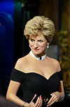 Voksfigur av Diana i svart, skulderbar kjole med perlesmykke og mørk bakgrunn på Musée Grévin i Paris.
