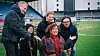 Fem personer, med Else foran, står samlet på fotballbanen ved Jotun Arena.