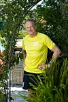 Frode Grodås står i gul treningsskjorte mellom grønne planter utendørs.