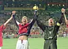 Frode Grodås i mørk keeperdrakt og en lagkamerat i rød drakt jubler med armene i været på stadion.