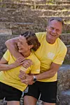 Frode Grodås holder rundt Astrid Lødemel mens begge ler i gule «Mesternes mester team»-trøyer.